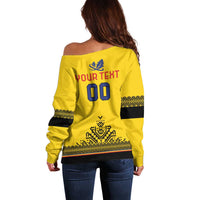 Yellow off-shoulder sweater with back print and dark striped sleeve cuffs
