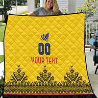 Yellow quilt with diamond stitching, blue "00" emblem, "YOUR TEXT" and patterned black trim