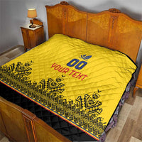 Yellow quilt on bed with diamond stitching, blue "00" crest, "YOUR TEXT" and black edge