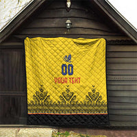 Yellow quilt hanging on wooden wall, diamond quilting, blue crest, "YOUR TEXT" and black border