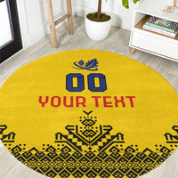 Round yellow rug with blue and red crest, bold “YOUR TEXT” lettering, geometric border