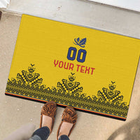 Yellow doormat with blue '00' and red 'YOUR TEXT', plus patterned border; shoes nearby.