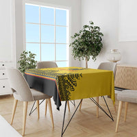 Yellow tablecloth with black panel and retro geometric border, draped over a dining table.