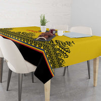 Yellow tablecloth with black underside and decorative geometric print along the edge.