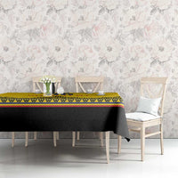 Yellow rugby tablecloth with black section and geometric stripe border on a dining table.