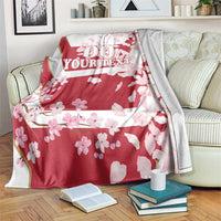 Red cherry blossom custom rugby blanket draped on sofa with '00 YOUR TEXT' design