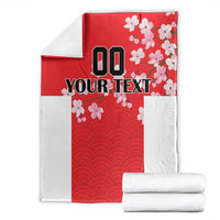 Folded red and white custom blanket with wave pattern and cherry blossoms