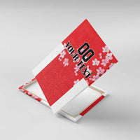 Tilted view of framed red wall art canvas with cherry blossoms, wave pattern, “YOUR TEXT”