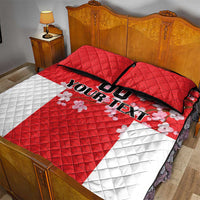 Red and white quilt bed set with black-trim border and cherry blossom accents