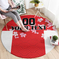 Red circular rug with wave pattern center, cherry blossoms, and bold custom text.