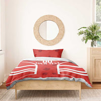 Red duvet with maple-leaf pattern and 'YOUR TEXT' over striped panels on bed