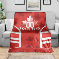 Red Canada flag-style rugby blanket draped over a gray sofa, white “YOUR TEXT” graphic
