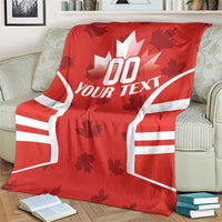 Red Canada flag-style rugby blanket covering a couch, maple leaf and “YOUR TEXT” design