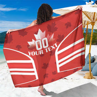Red Canada flag sarong with maple leaves and white stripes, held up for display
