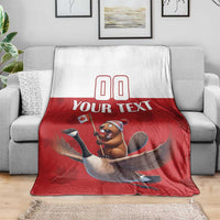 Custom rugby blanket on gray sofa, red lower half with beaver riding goose graphic