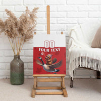 Red canvas wall art with bear riding goose illustration and custom text, on easel