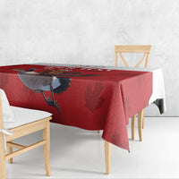 Red tablecloth draped over table edge with goose and maple leaf motif