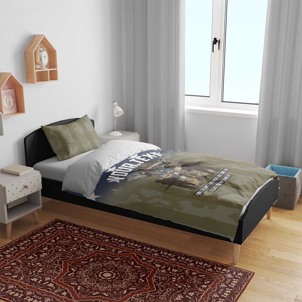 Personalized bedding set on bed: olive camo duvet with blue star design and “YOUR TEXT”
