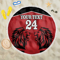 Round red beach blanket with black lion heads, white fringe, center text "YOUR TEXT 24"