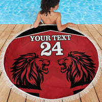 Round red beach blanket with black lion heads, white fringe edge, "YOUR TEXT 24" print