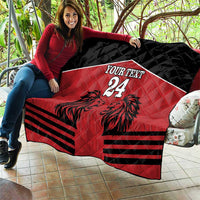 Red and black quilt blanket with lion design, 'YOUR TEXT' and number 24 draped on a seat.