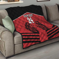 Red and black quilt blanket with lion design, 'YOUR TEXT' and number 24 on a sofa.