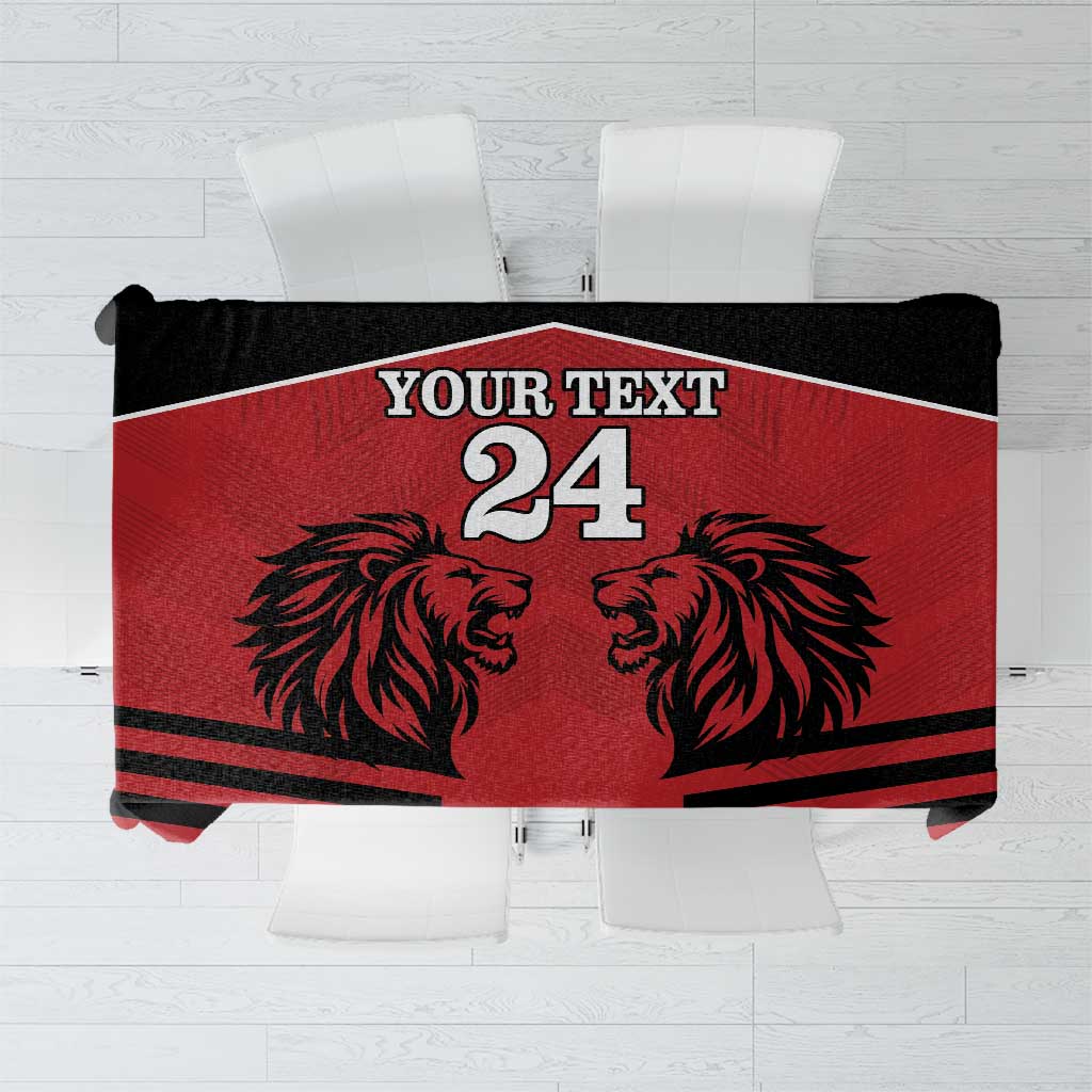 Red tablecloth with black lion head graphic and rugby-style stripes