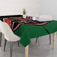 Green tablecloth draped on dining table, showing black and red graphic border