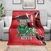 Red blanket featuring green lion, Kenya lettering, and black flag-like design on sofa