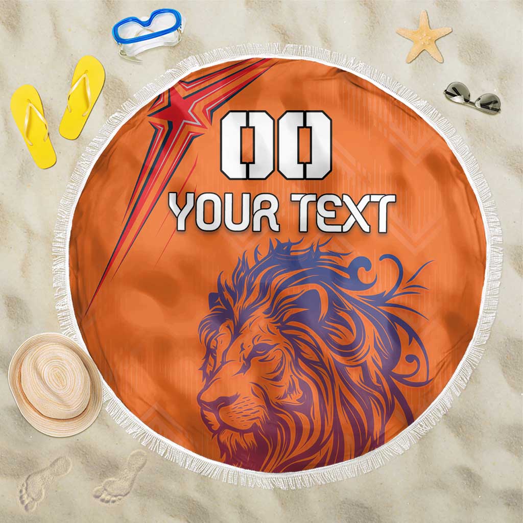 Orange round beach blanket with blue lion face, “YOUR TEXT” and white fringe
