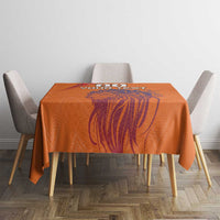 Orange printed tablecloth draped on a square table with lion graphic centered