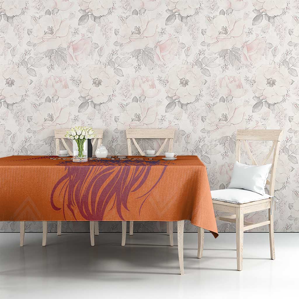 Orange printed tablecloth with lion manestyle artwork on a rectangular dining table