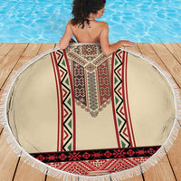 Round beige beach blanket with red and green geometric embroidered vertical panels and fringe