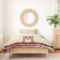 Beige duvet and pillows with red patterned embroidery band along the bottom