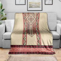 Beige throw blanket with red, black, and green embroidered vertical panel and border.