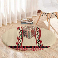 Beige round rug with red bottom border band and diamond-pattern embroidery center