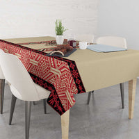 Beige tablecloth with red, black, and cream patterned trim along table edge