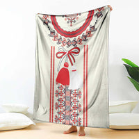 Light blanket with Romanian folk dress and woven border pattern in red, blue, and black
