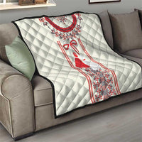 White quilt with quilted diamond texture and red dress motif framed by Romanian trim