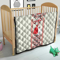White crib quilt with quilted diamonds and red-and-black Romanian dress graphic