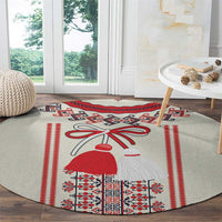 Beige round carpet with red striped border and central costumed girl folk design