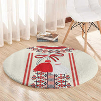 Beige round carpet with central costumed girl, red border stripes, and folk blocks