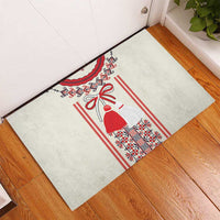 Beige rubber doormat with red geometric trim and a red-and-white angel bell design