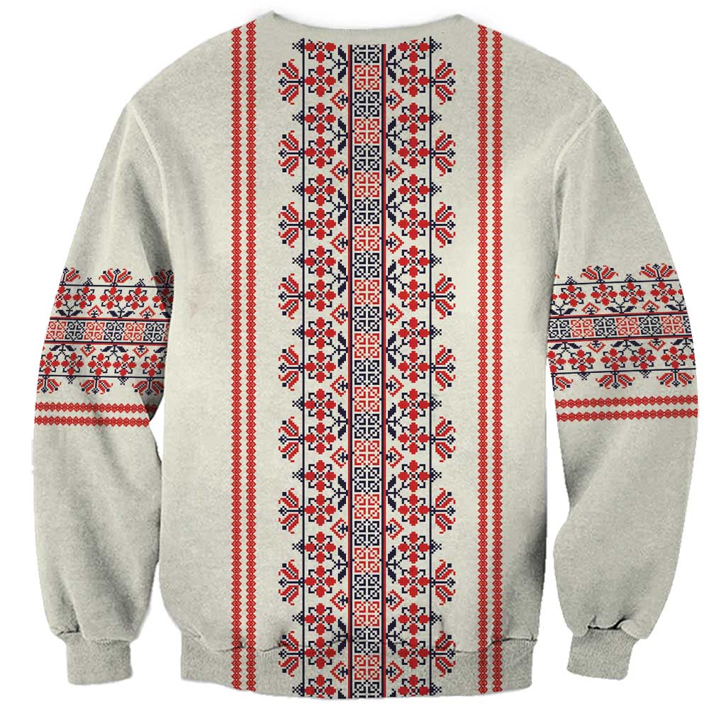 Beige crewneck sweatshirt with vertical red, black, and white folk border panel