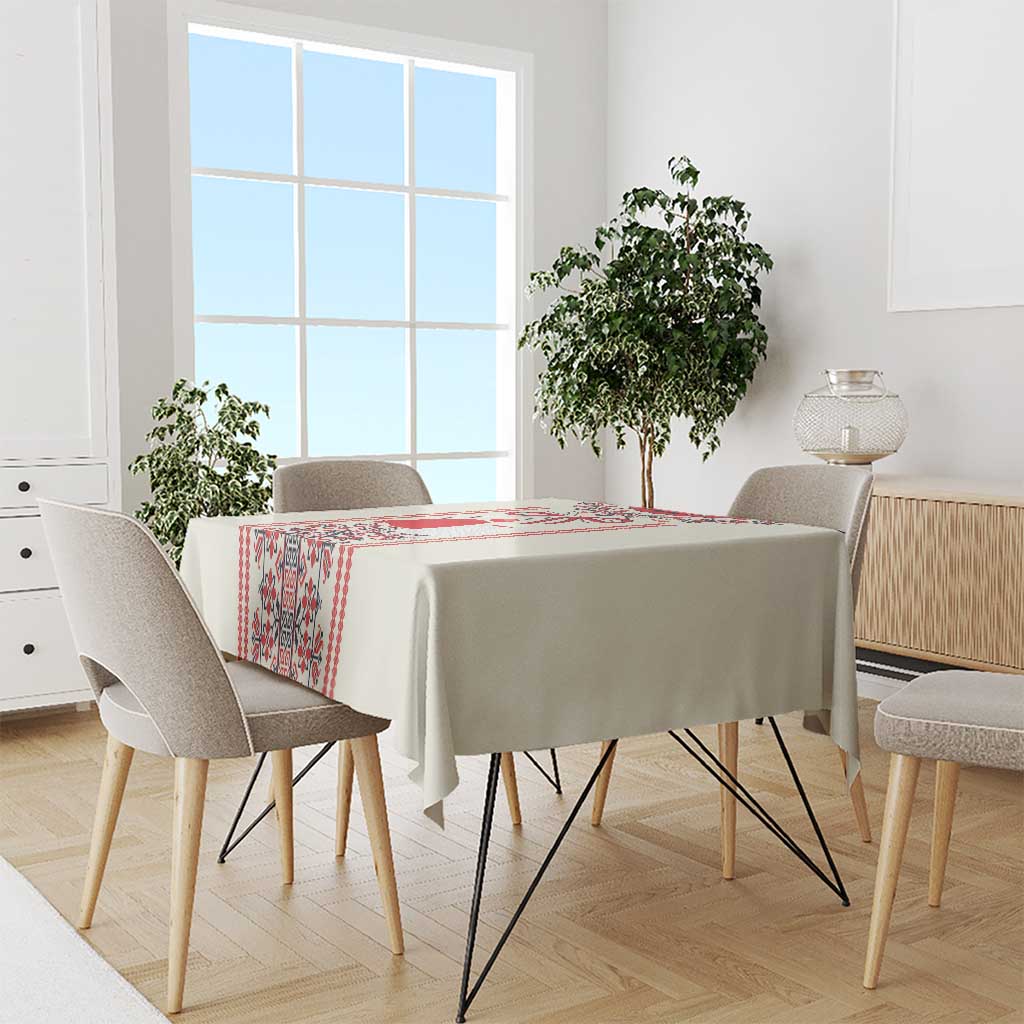 Beige tablecloth with red folk trim along the edges on a dining table