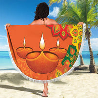 Round orange beach blanket with white fringe and large rangoli mandala with diya candles.