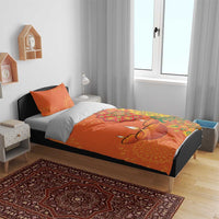 Orange bedding set on bed with rangoli mandala pattern and two matching orange pillow shams
