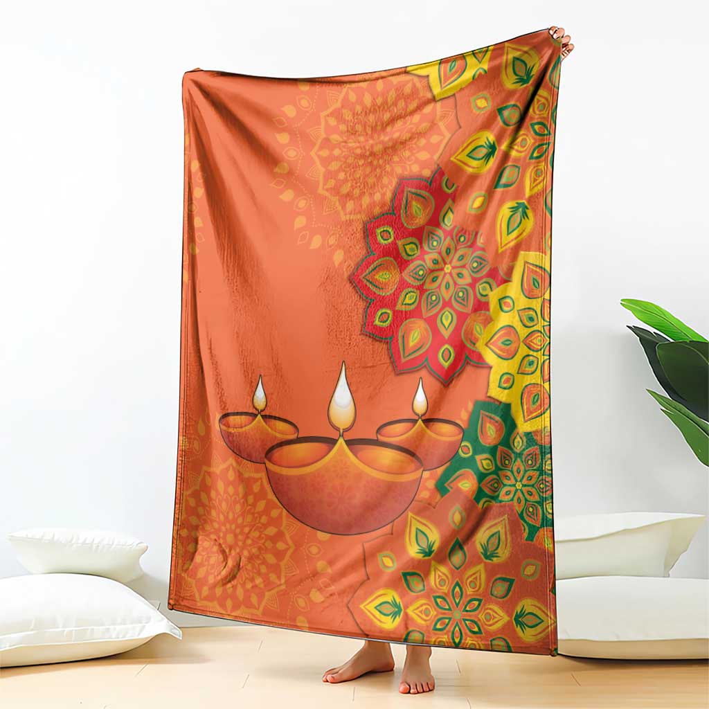 Saffron Diwali throw blanket draped over lounge chair, with diya rangoli medallion print