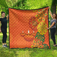 Orange quilt spread outdoors with rangoli-style floral diya candle design