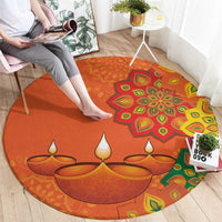 Round orange rangoli carpet with diya motif and bright green, yellow, red details